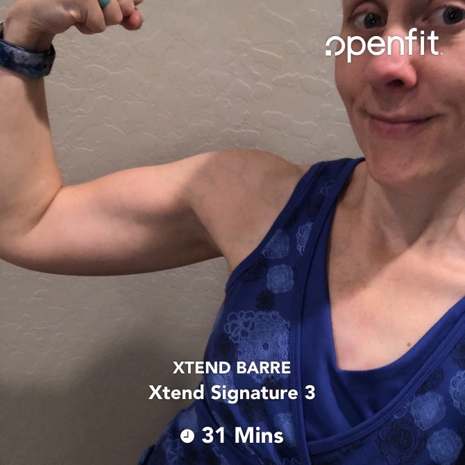 Flexing after doing an Xtend Barre workout in the OpenFit app. 