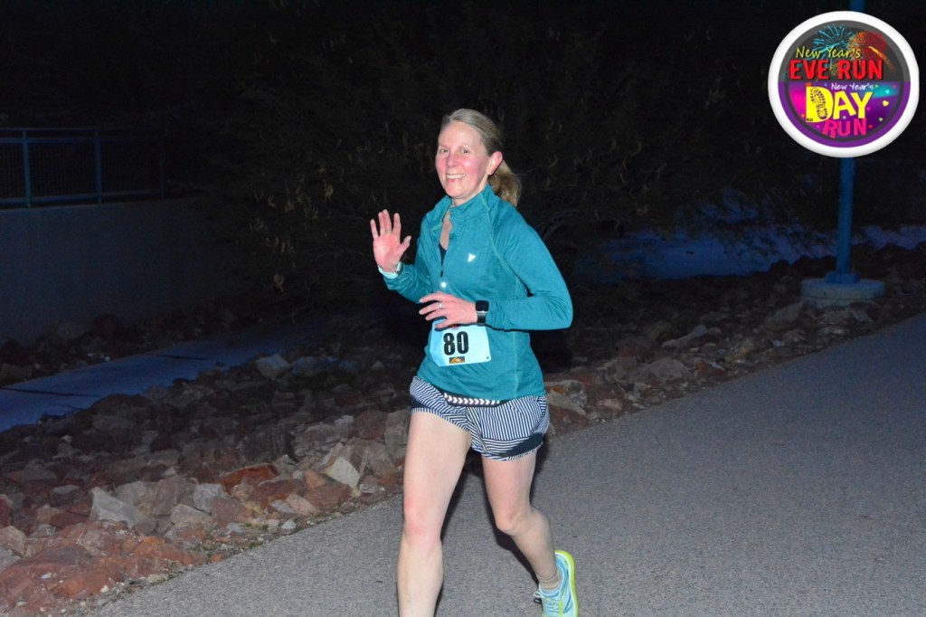 Mid-run photo of me running and waving at the camera during the Resolution Run 5K on 12/31/2025